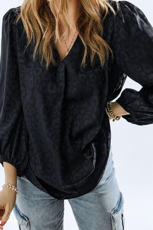 a woman wearing a black blouse and jeans