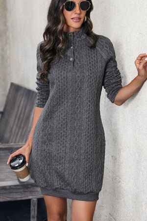 a woman standing next to a wall holding a cup of coffee