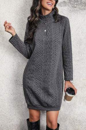 a woman in a gray sweater dress holding a cup of coffee