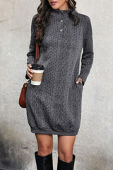 a woman in a gray sweater dress holding a cup of coffee