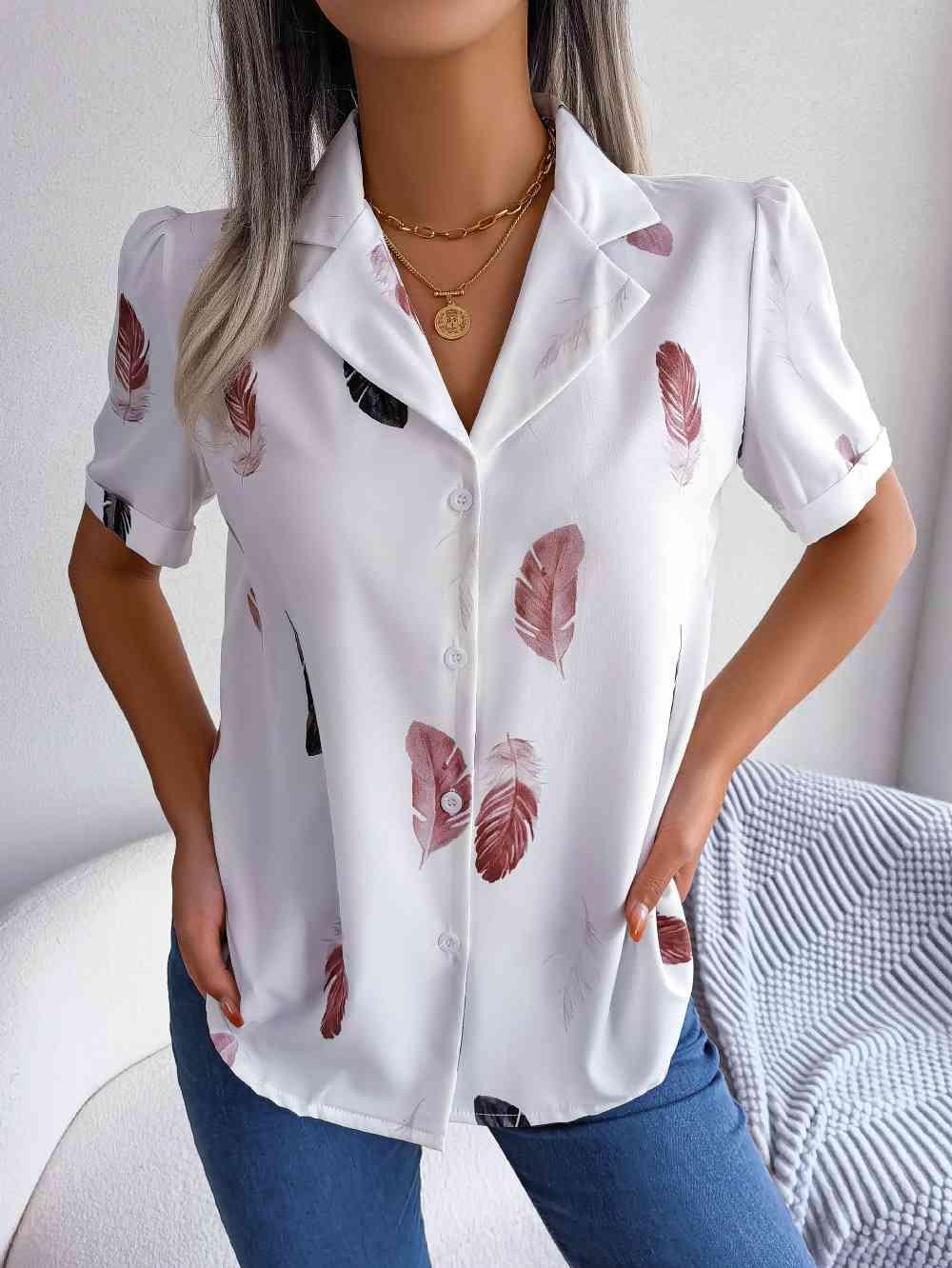 a woman wearing a white shirt with red leaves on it