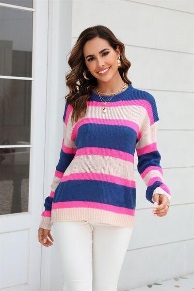 a woman wearing a striped sweater and white pants