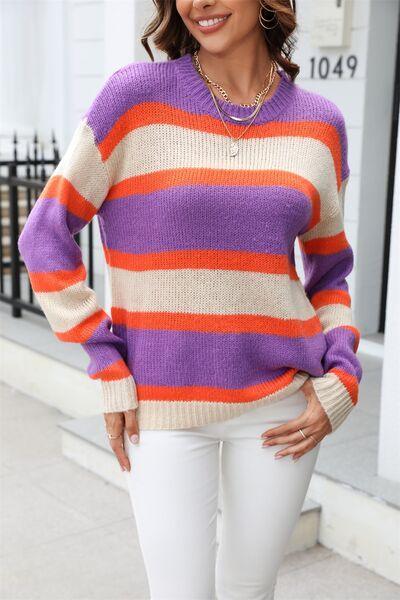 a woman wearing a striped sweater and white pants