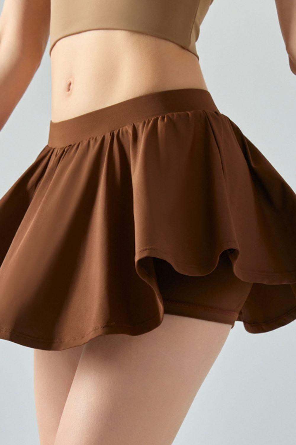 a woman in a tan top and brown skirt
