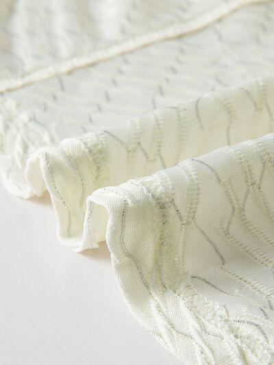 a close up of a white blanket on a white surface