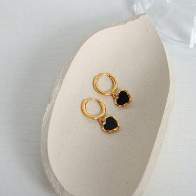 a pair of gold earrings with black stones