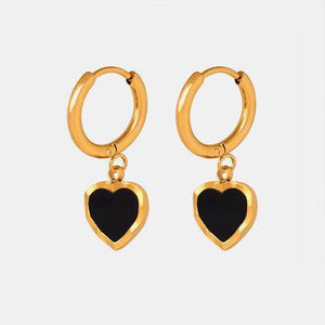 a pair of black and gold heart shaped earrings