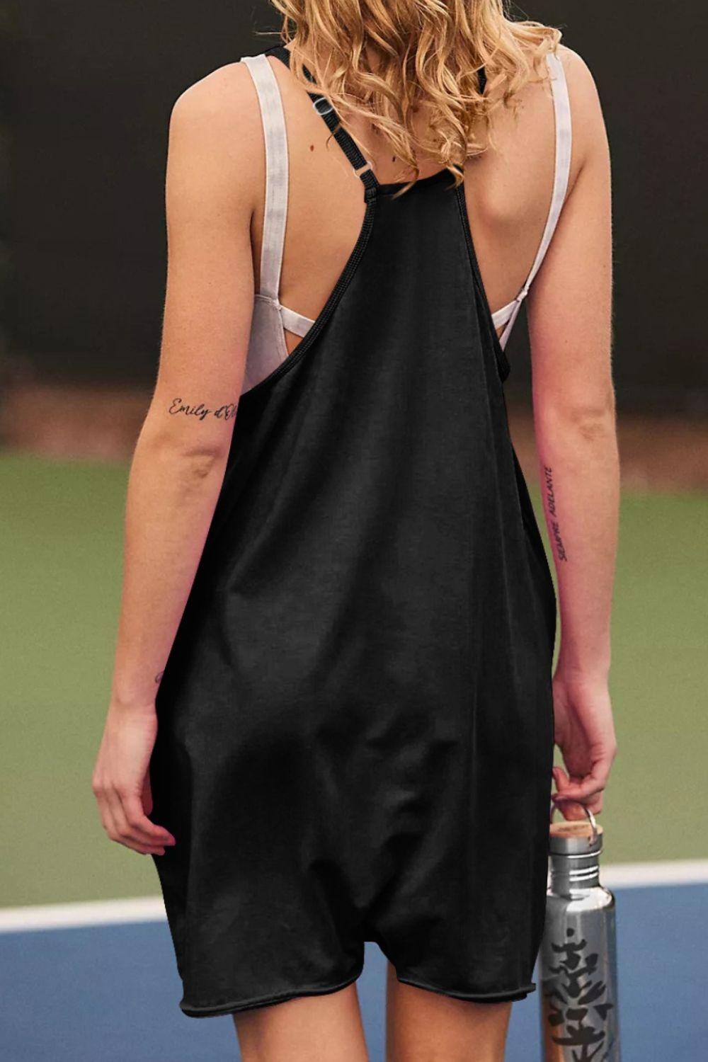 a woman in a black dress holding a tennis racquet