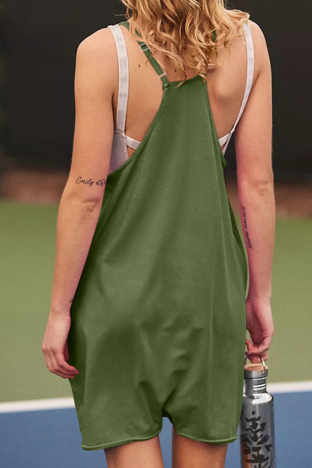 a woman in a green dress holding a tennis racquet