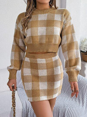 a woman wearing a brown and white checkered sweater and skirt