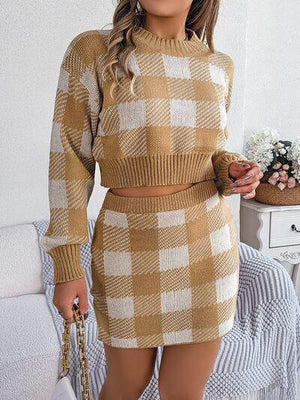a woman wearing a brown and white plaid sweater and skirt