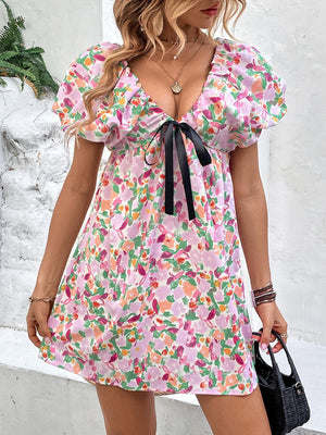 a woman in a floral dress holding a black purse