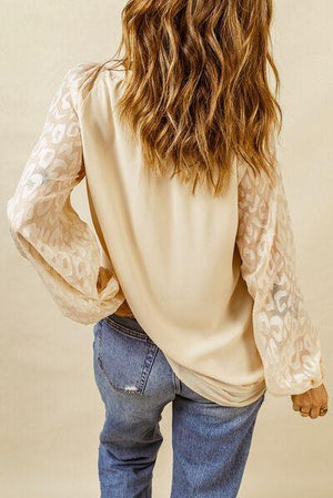 a woman with long hair wearing a blouse and jeans