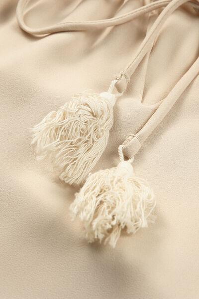 a close up of a bag with tassels on it