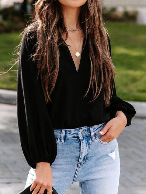 a woman with long hair wearing a black shirt and jeans