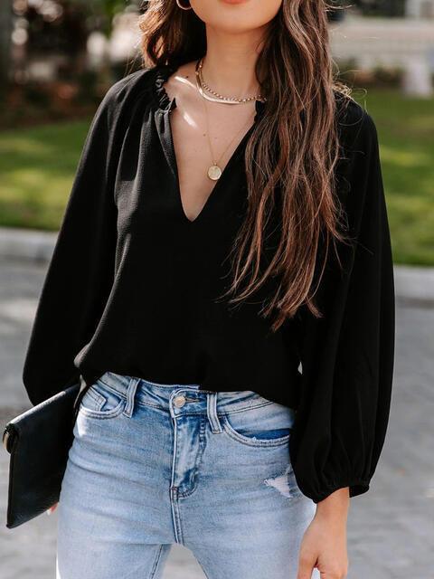 a woman wearing a black top and jeans