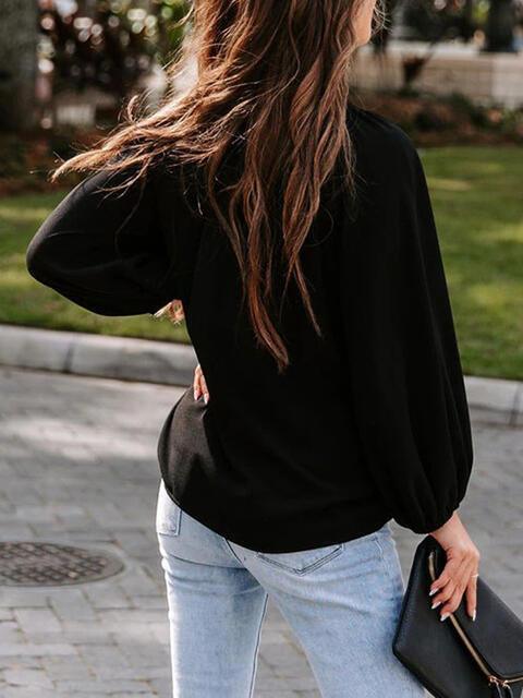 a woman walking down a sidewalk carrying a black purse