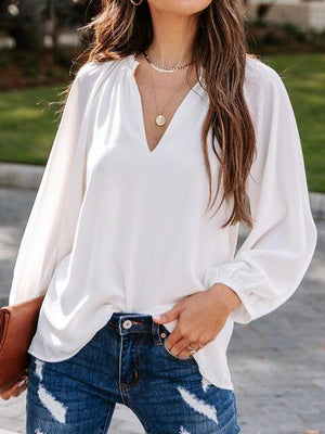 a woman wearing a white blouse and jeans