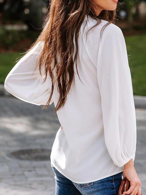 a woman with long hair wearing a white shirt and jeans