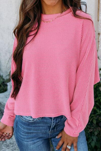 a woman wearing a pink sweater and jeans