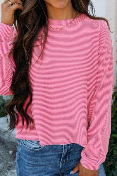 a woman wearing a pink sweater and jeans