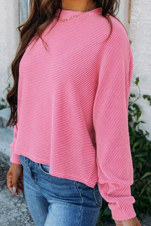 a woman wearing a pink sweater and jeans