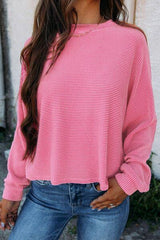 a woman wearing a pink sweater and jeans