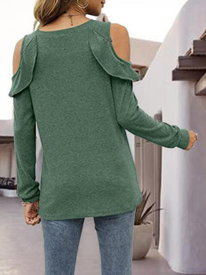 a woman wearing a green sweater and jeans