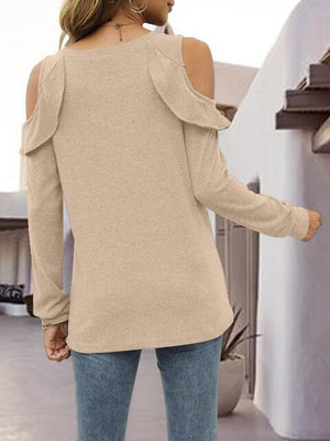 a woman wearing a tan sweater and jeans