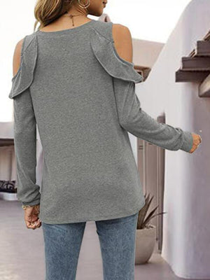 a woman wearing a grey sweater and jeans