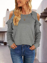 a woman wearing a grey top and jeans