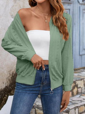 a woman wearing a green cardigan sweater and jeans