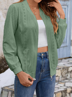 a woman wearing a green cardigan sweater and jeans