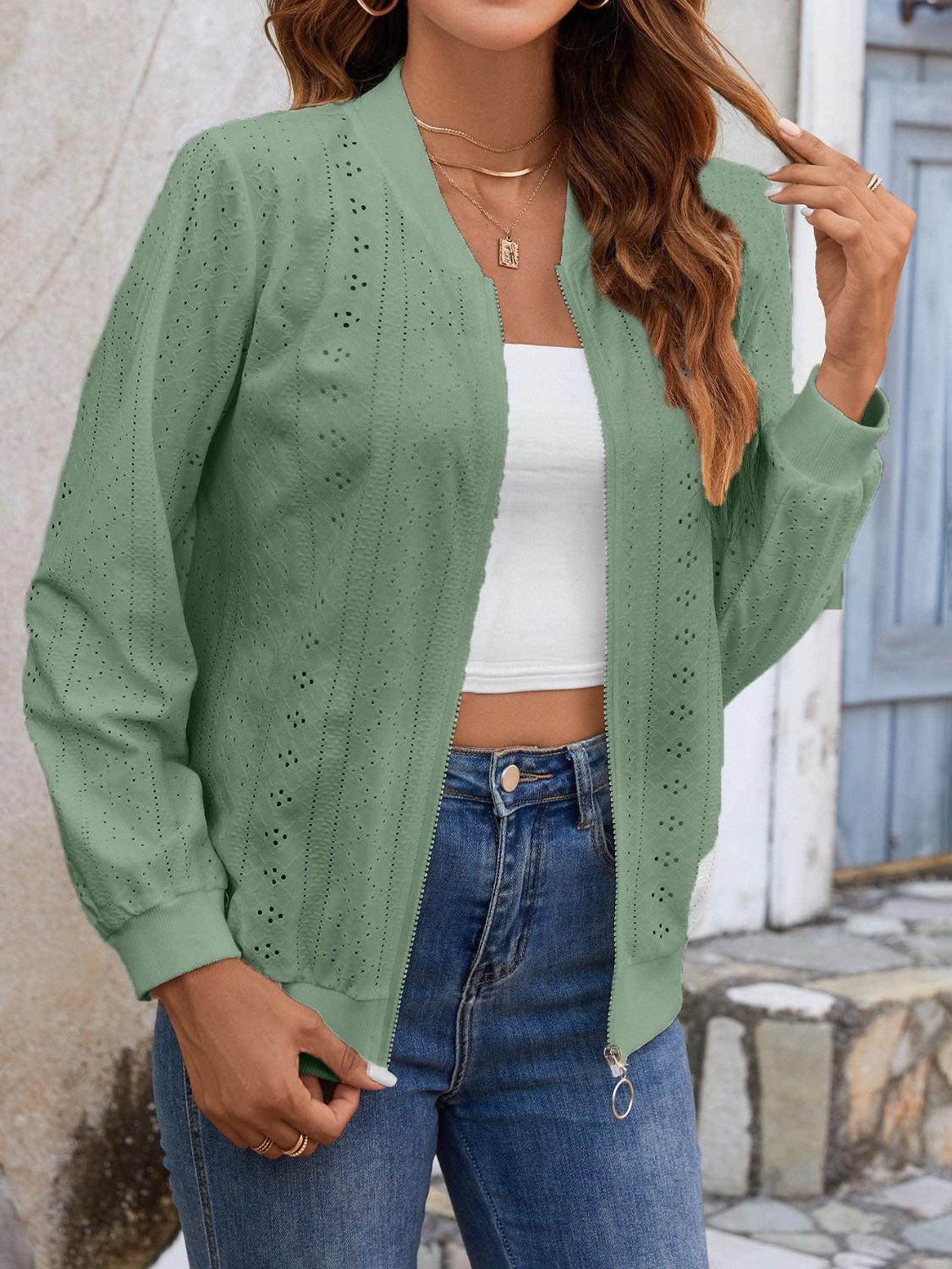 a woman wearing a green cardigan sweater and jeans