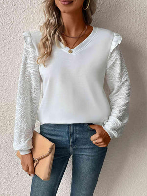 a woman wearing a white blouse and jeans