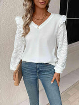 a woman wearing a white top and jeans