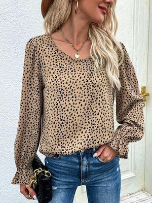 a woman wearing a leopard print blouse and jeans