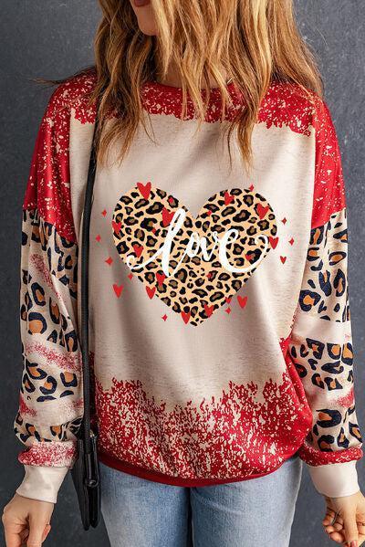 a woman wearing a leopard print heart sweatshirt