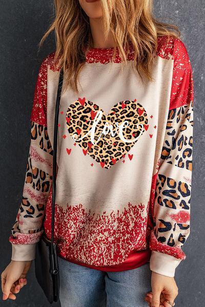 a woman wearing a leopard print heart sweatshirt