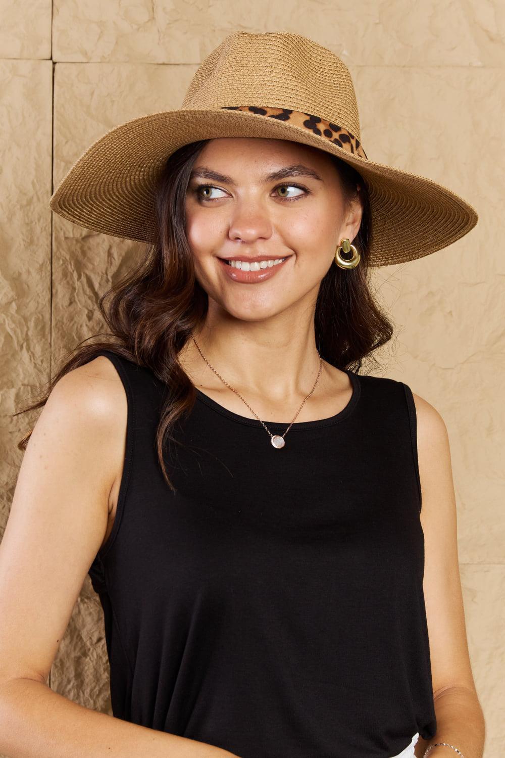 a woman wearing a black top and a brown hat
