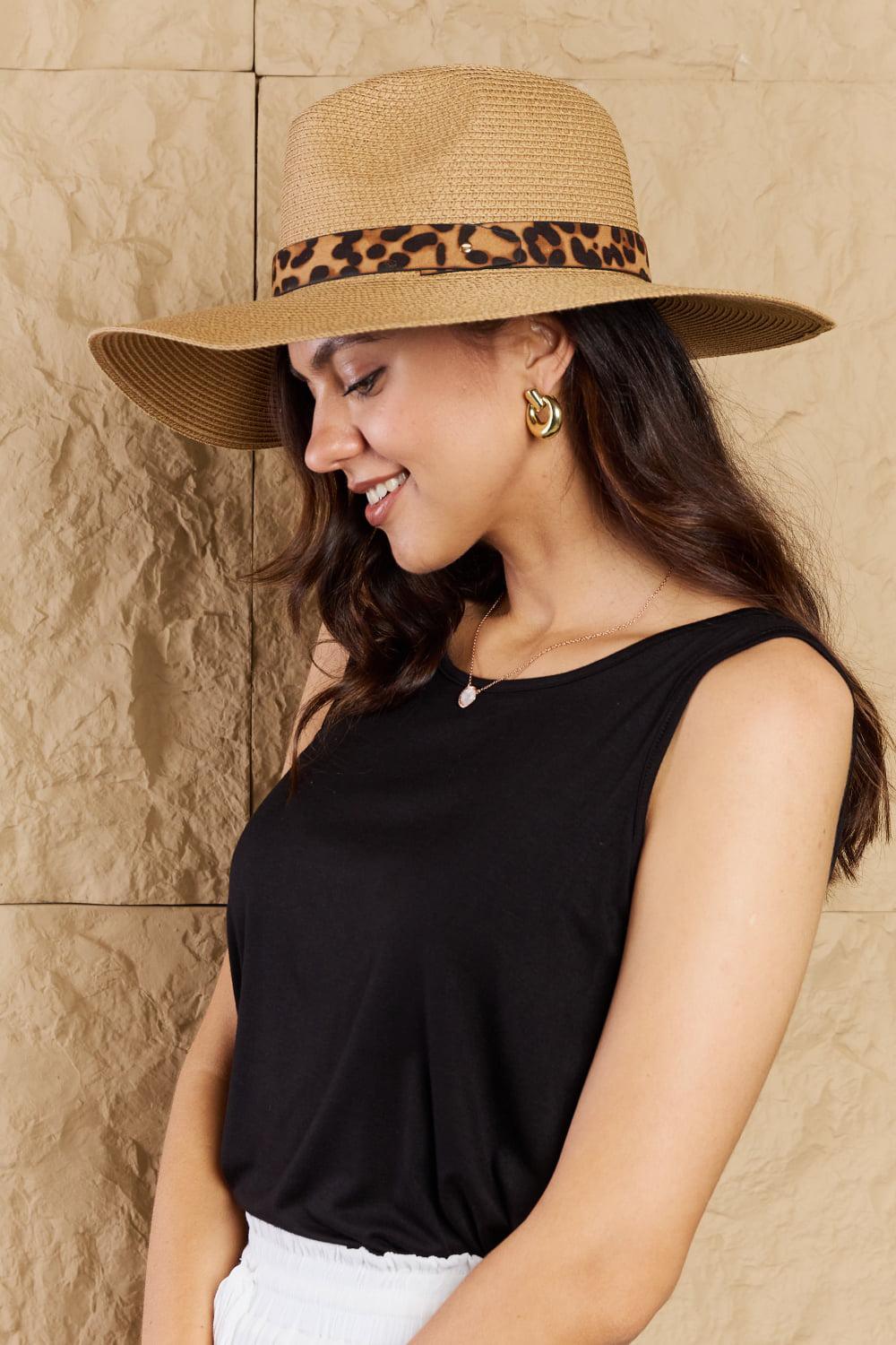 a woman in a black top and a brown hat