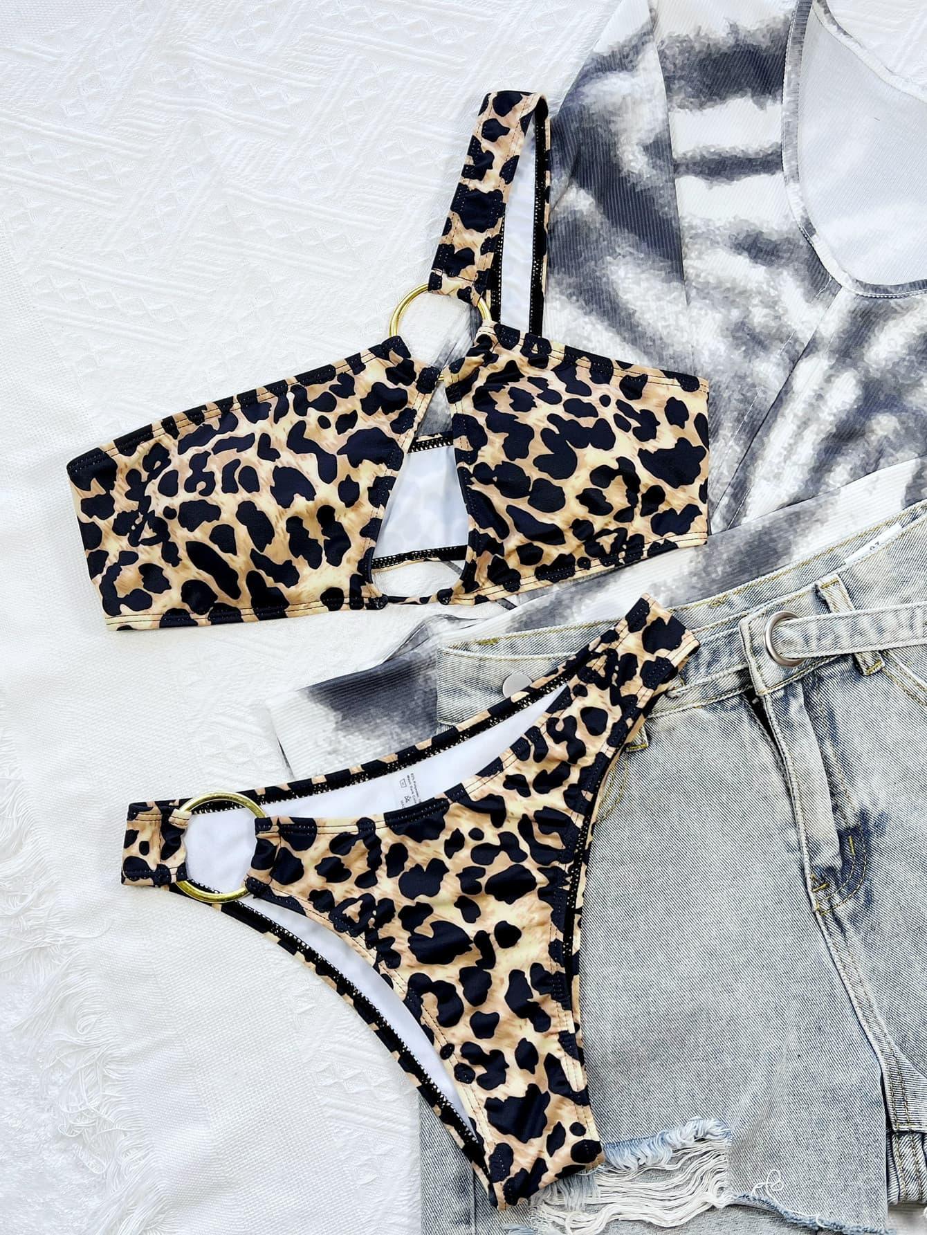 a pair of leopard print bikini tops next to a pair of denim shorts