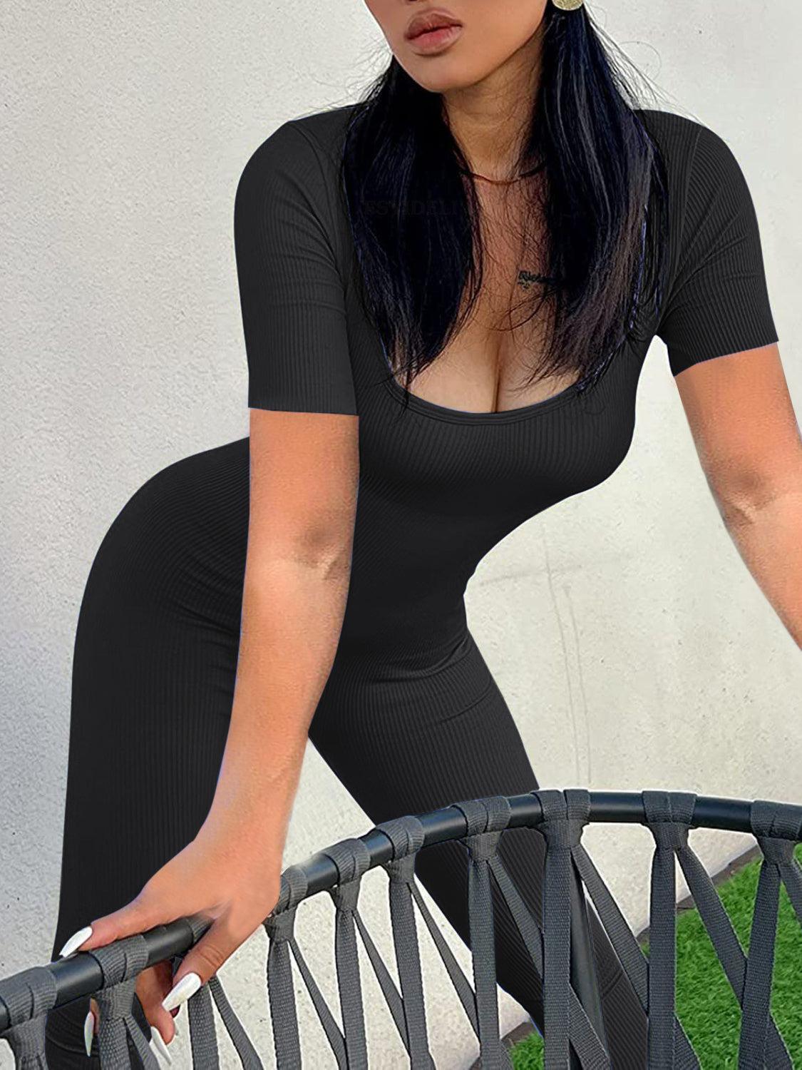 a woman in a black bodysuit leaning on a railing