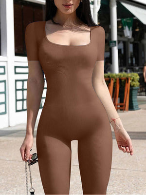 a woman in a brown bodysuit walking down a street