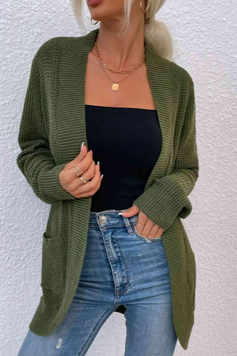 a woman wearing a green cardigan sweater and jeans