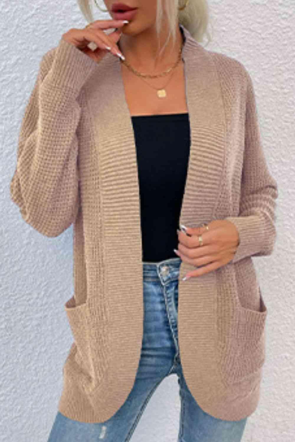 a woman wearing a cardigan sweater and jeans