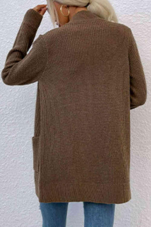 a woman wearing a brown sweater and jeans