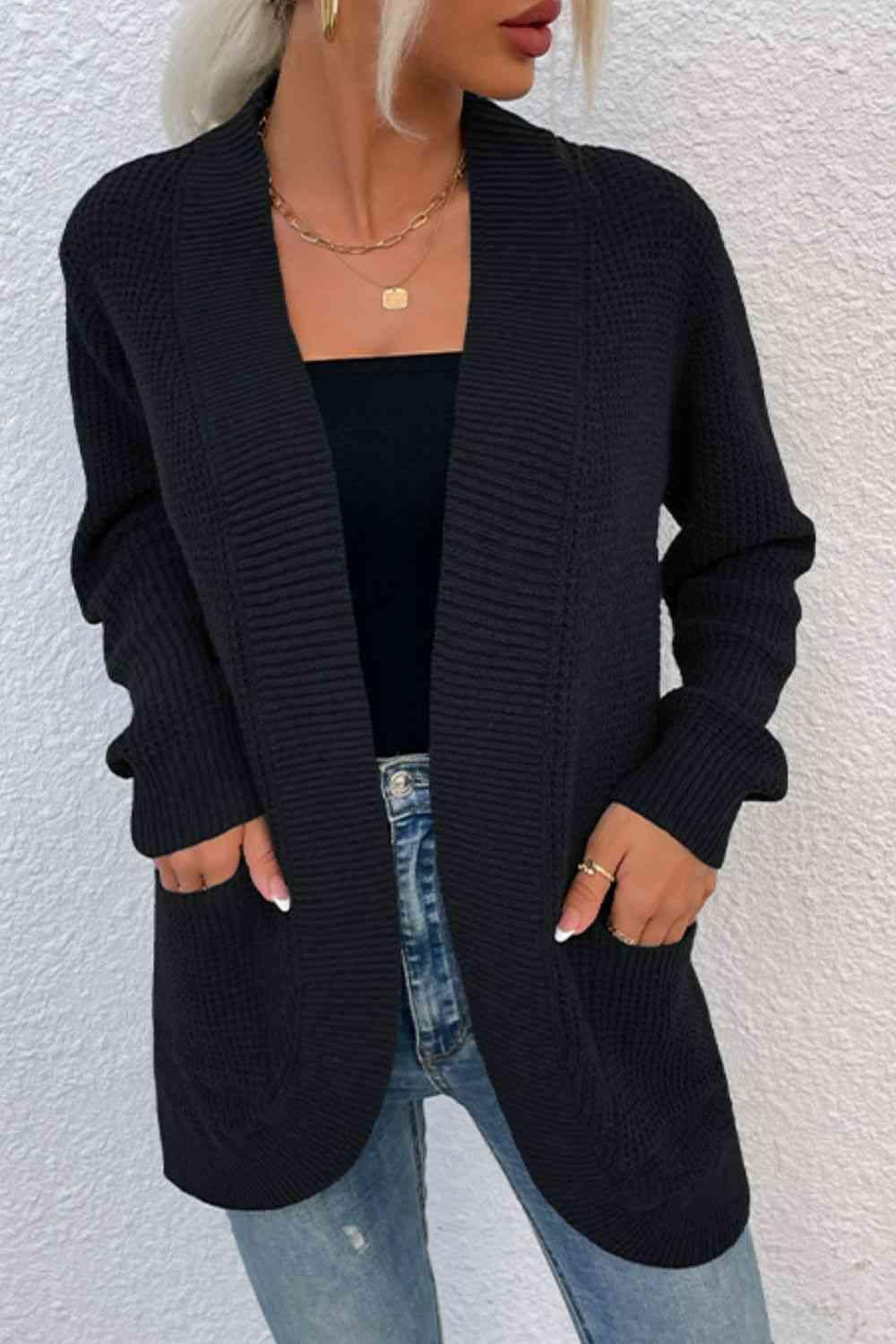 a woman wearing a black cardigan sweater and jeans