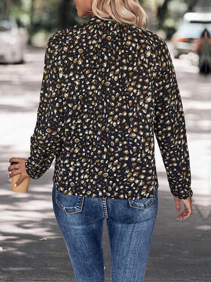 a woman walking down the street wearing a leopard print shirt