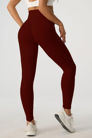 a woman in a white top and maroon leggings
